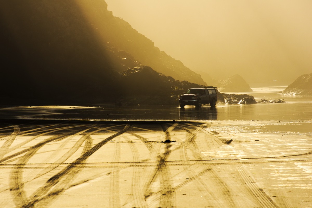 ford truck beach sand wet ocean rocks gold light